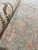 Macro shot of low quarter inch wool pile with peach diamond motif on sage ground