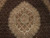 Close-up of ivory lobed medallion ringed by tiny herati fish motifs in wool and silk