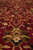 Macro of burgundy pile with gold palmettes, green leaves and fine silk highlighted blossoms