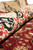 Rolled edge close-up showing the silky sheen of wool and silk pile in the black border