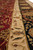 Border detail along the length showing ivory vine stripe between burgundy field and black band