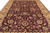 Perspective view of maroon Kashan design rug with palmettes, vines and gold guard borders