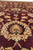 Central palmette and cream floral vinework across the deep maroon field, low angle detail