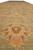Close view of palmette motif with rust rosette centers on washed sage green wool