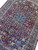 Burgundy field and all over floral vinework photographed at an angle across the wool pile