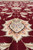 Detail of cream palmette motif with lilac and peach petals set in maroon ground