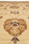 Close view of a large gold and coral palmette on the creamy beige field