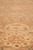 Close-up of floral palmettes and rosettes woven across the copper toned square rug field