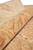 Rolled edge close-up showing the soft natural wool pile in peach, rust and gold