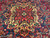 Macro of the star medallion core, cross rosette in green, blue and burgundy hand-knotted wool