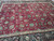 Close view of the crimson field with turquoise, salmon and ivory palmettes in all over design
