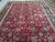 Full field of the oversize Persian rug showing symmetrical vine scroll, rosettes and dark indigo main border