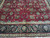 Woven signature cartouche in the ivory guard border above the navy palmette border of the rug