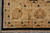 Corner detail of ivory main border with black leaf motifs above ivory cotton fringe