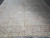Wide shot of square Oushak wool rug showing symmetrical floral repeat and faded brick border