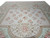 Wide angle of the ivory medallion field, rose garlands and mint green spandrels on this handmade rug