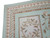 Corner detail of braided guard borders, ribbon twist bands and pale green outer edge