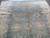 Corner detail showing ivory main border, serrated leaves and creases from rolled storage on wool