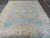 Full length photo of the 9' x 11'7" Indian Oushak rug with wide ivory border