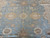 Detail of camel and cream palmette medallions linked by delicate vine scroll on blue ground