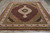 Hand-knotted Oriental rug on wood floor, ivory floral main border framing the burgundy Herati field