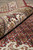 Rolled edge showing ivory main border palmettes beside the red field and dense wool pile