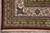 Corner detail with ivory turtle palmette border, burgundy outer band and clean cotton fringe