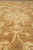 Close-up of wool pile texture showing ivory palmettes dissolving into the warm camel brown field