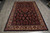 Angled floor view showing the all over floral spray pattern and cream palmette border of this Sarouk
