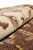 Rolled edge showing the thick soft natural wool pile in ivory and brown floral drawing
