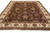 Angled floor view showing repeating floral drawing across the chocolate brown field and cream border
