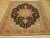 Black and rust Tabriz rug photographed on light parquet flooring showing ivory corner spandrels and fringe