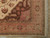Corner detail showing salmon main border, sage guard stripes and ivory fringe on wool rug