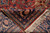 Folded corner showing hand-knotted back, cotton foundation and cream fringe of this rug