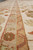 Detail of rust outlined inner border and gold vine band running along the rug edge