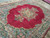 Angled view of hand-knotted Kerman wool rug with scalloped medallion and multi-color floral border detail