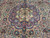 Central medallion macro showing ivory and pistachio green petals over deep navy with crimson palmettes