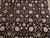 Close-up of black wool pile showing rose vine scroll, palmettes and multicolored floral rosettes