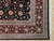 Corner detail showing burgundy main border, slate blue guard stripes and ivory fringe on wool rug