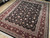 Angled floor view of 7'11" x 9'11" hand-knotted rug on light wood showroom flooring
