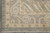 Corner of the ivory border showing blue cloudband scrolls, olive rosettes and clean weave lines