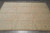 Angled floor view of ivory main border and soft green guard stripes on large room size rug