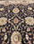 Detail of blossoming vine scrollwork in cream, gold and rose across the deep brown ground