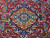 Center medallion of this 10x13 Kashmar rug framed by curling vines and blue cartouches