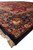Low angle along navy border showing olive green cartouche flowers and deep red outer stripe