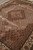 Close perspective across the herati lattice and scalloped medallion reserve in beige and rust tones