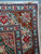 Corner close-up of ivory guard borders with red rosettes, blue birds and small gazelle figures