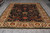 9' x 12' Oriental rug laid flat in showroom, dark blue center framed by ivory border