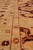 Low angle across the gold border showing hand-spun wool texture and small rosette motifs
