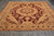 Angled floor view of gold ground Oriental rug with burgundy medallion and floral border